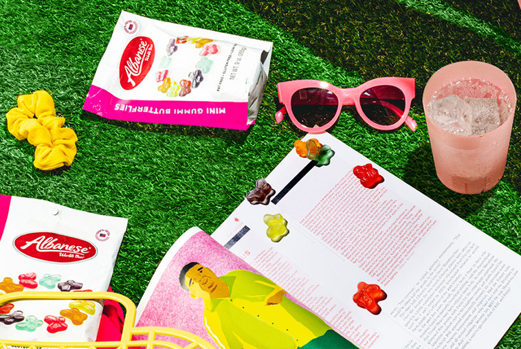 A magazine in the grass with gummi butterflies strewn about